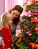 Mother and daughter in front of Abies nordmanniana as Christmas tree