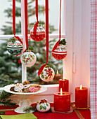 Weihnachtsbaumkugeln mit nordischen Motiven im Fenster hängend