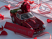 Rosa (rote Rose) auf kleinem Ferrari mit Textbotschaft
