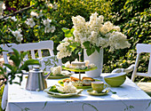 Table decoration with Syringa (lilac) as bouquet, on etagere