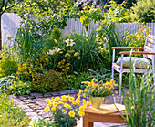 Terrasse am gelb-grünen Beet mit Stauden und Gräsern