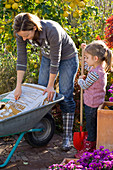 Mother and daughter planting terracotta pots (1/4)