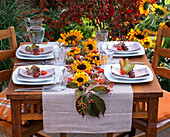 Herbstliche Tischdeko mit Sonnenblumen und Kastanien
