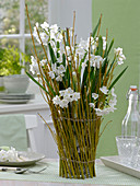 Fence of dogwood branches around glass vase (3/3)