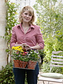 Junge Frau mit frisch gekauften Primula elatior (Frühlingsprimeln), Viola