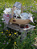 Picknickkorb auf Beistelltisch in der Blumenwiese