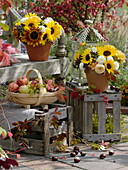 Herbstdekoration mit Sträuße und Äpfel auf und vor der Bank