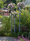 Painted pots on painted rods in the flower bed