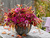 Pink-red autumn bouquet in wicker basket