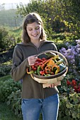 Young woman holding chip basket with chillies and peppers