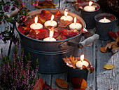 Floating candles with autumn leaves floating in zinc tub