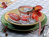 Glass with floating candle as napkin decoration