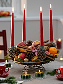 Wire basket with 4 candle holders as Advent wreath, filled with cinnamon sticks