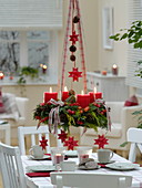 Mixed Christmas wreath with red candles hung over the table