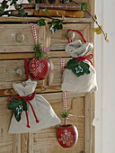 Linen bags with numbered ivy leaves and decorative wooden apples