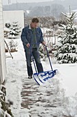 Man clearing snow with a snow lady