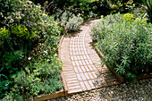 Front Garden DESIGNED by JUDITH SHARP with CURVED BRICK PATH, EUPHORBIA, DAPHNE AND OTHER SCENTED PLANTS