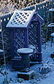 Purple COVERED SEAT FLANKED by Metal URNS AND BACKED by Blue DECORATIVE FENCING IN THE NICHOLS Garden at 69, ALBERT Road, READING, COVERED with SNOW