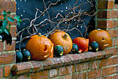 Halloween: Fensterbank dekoriert mit Kürbissen, Kürbissen, Weidenruten, Sternen und schwarzem Karton