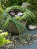 Wreath of grasses on a stone trough with floating candles