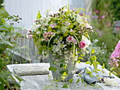 White-pink bouquet with roses, woody flowers and herbs