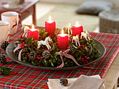 Naturally decorated Advent wreath made of holly with red candles