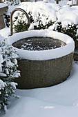 Verschneiter Brunnen aus Granit
