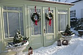 Snowy garden house decorated for Christmas with wreaths