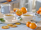 Hot orange tea in cups, oranges (Citrus sinensis)