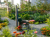 Bauerngarten mit Brunnen in der Mitte, Beete mit Gemüse, Salat, Kräutern