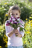 Girl with a fragrant bouquet of Lathyrus odoratus (scented vetch)