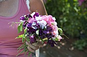 Woman with bouquet of Lathyrus odoratus (sweet pea)