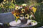 Colourful country garden bouquet in wooden bucket