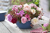 Blue bowl with pink arrangement (roses and rosehips)