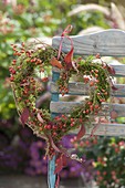 Heart of moss and pink (rosehips), decorated with wired leaves