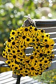 Wreath of Rudbeckia fulgida (coneflower) on the back of a chair