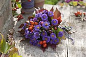 Kleiner Strauß aus Aster (Herbstastern), Rosa (Hagebutten) und Blättern