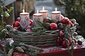 Advent basket with red baubles, candles with deer decoration