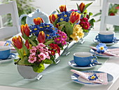 Primel-Tulpen-Tischdeko mit bepflanzten Zink-Rinnen