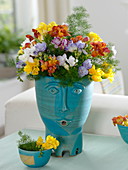 Colourful scented bouquet of freesia (freesia) in hand-potted pot with face