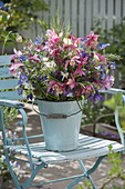 Bouquet of aquilegia (columbine) and grasses in enameled bucket