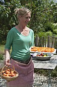 Aprikosen trocknen : Frau mit aufgeschnittenen, entkernten , halbierten