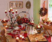 Table with apple pie and apple decoration, Rosa (roses) and rose hips, Malus (apples)