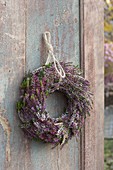 Wreath of Calluna vulgaris (Bud-flowering broom heather) on an old wooden door