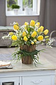 Strauss mit gelben Tulipa (Tulpen) und Spiraea (Spierstrauch) in Vase