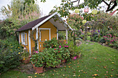 Gartenhaus mit Geranien in Töpfen