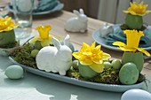 Easter table decoration with narcissus and easter bunny