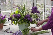 Arrange bouquet of syringa, betula and grasses