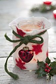 Small glass as a lantern in felt-coat-white with red stars