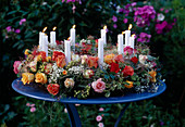 Rosary with candles on blue table